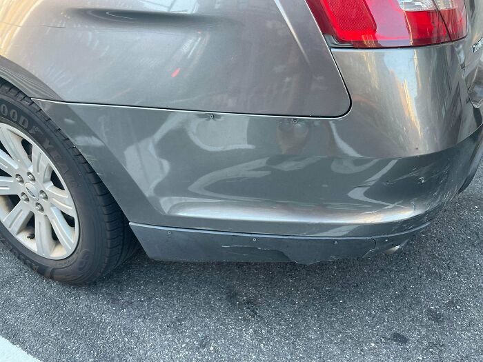 Car bumper held together with multiple screws as a technically works but unconventional solution to damage.