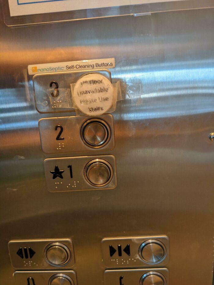 Elevator panel with taped-over 3rd floor button and handwritten sign saying use stairs, a technically works solution.
