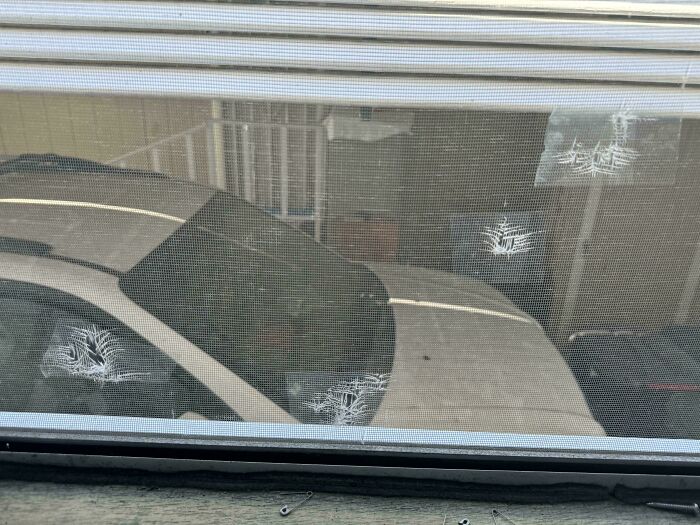 Car window screen with multiple cracks patched with white tape, a technically works but dumb solution to damage.