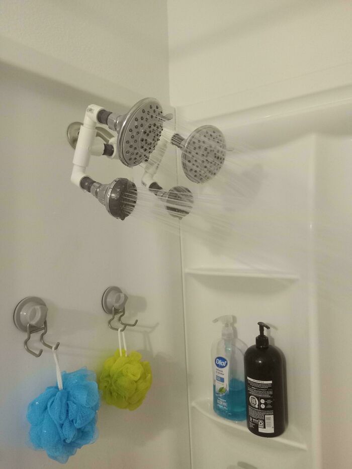 Shower with multiple showerheads connected in a DIY setup, illustrating a technically works but unusual solution.