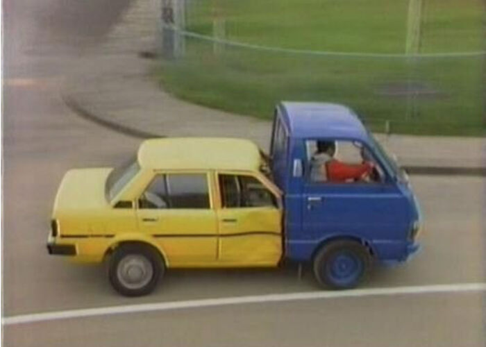 A yellow car and a blue truck humorously combined to create a technically works solution for transportation problems.