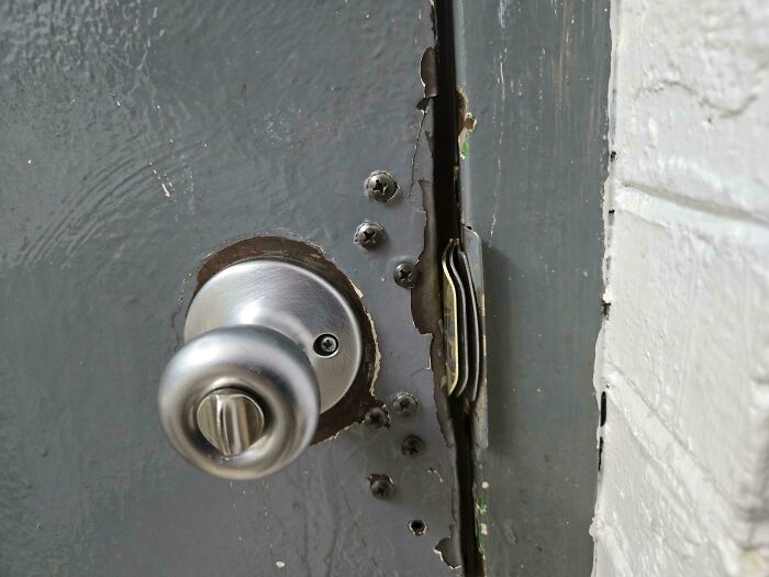 Door latch gap fixed with stacked coins as a technically works but dumb solution to door problems.