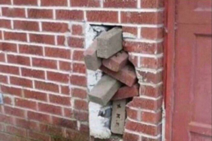 Hole in brick wall filled with loosely stacked bricks as a technically works but hilariously dumb solution to a problem.