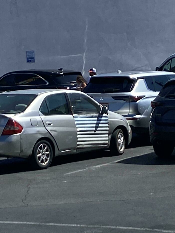 A car with a hilariously dumb but technically works solution, replacing the rear door with corrugated metal sheet.