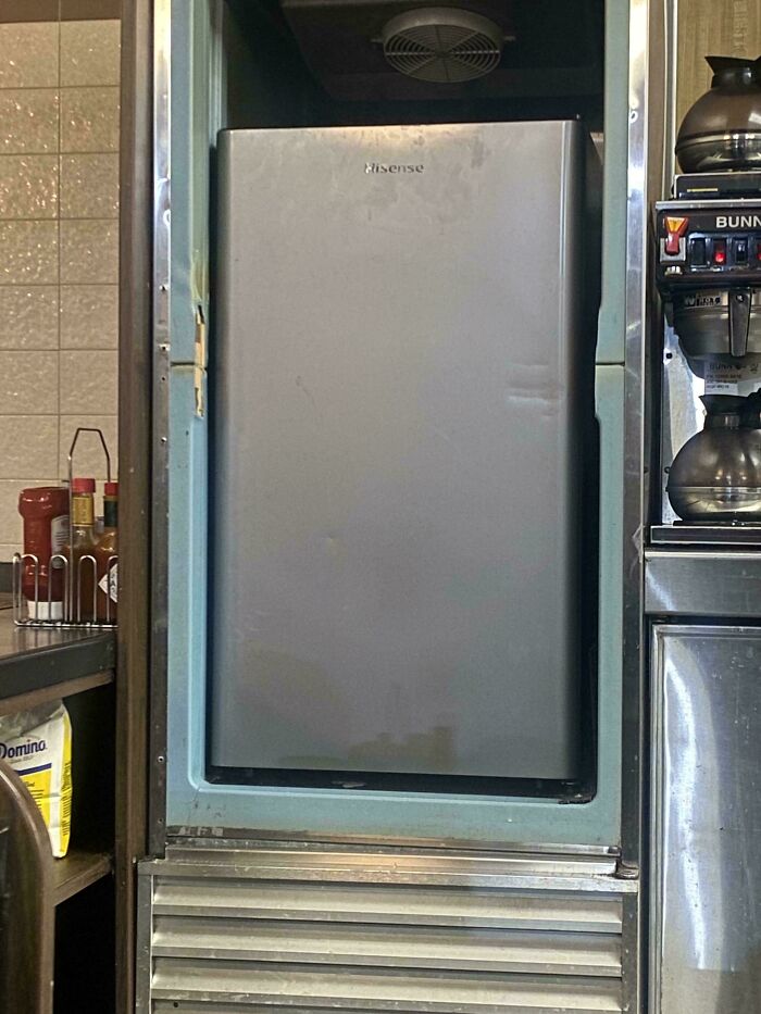 Mini fridge inside an ice machine compartment, a technically works hilariously dumb solution to cooling problems.