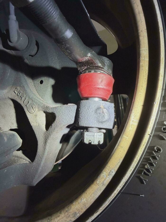 Car suspension part with a nut held by a metal bracket as a technically works, hilariously dumb solution.