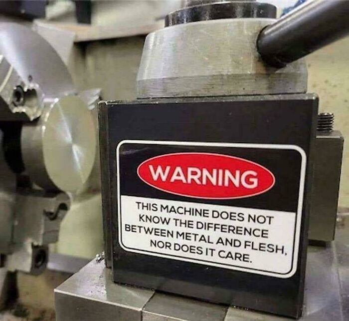 Warning sign on a machine stating it does not know the difference between metal and flesh, a confusing and funny bees sign.