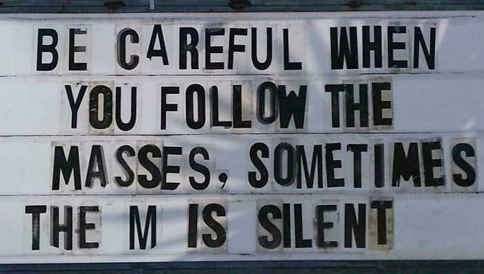 Funny confusing sign displayed on a lightbox reading a silent M in the word masses as a joke about bees.