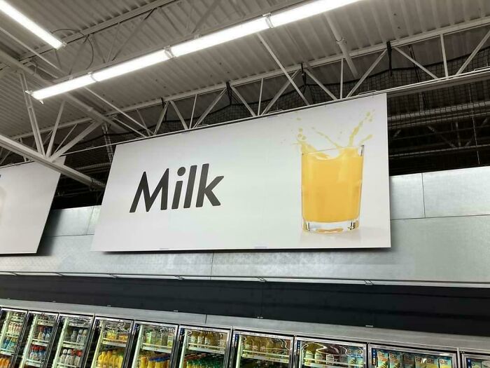 Store sign labeled milk with an image of orange juice, a confusing and funny sign featuring bees concept.