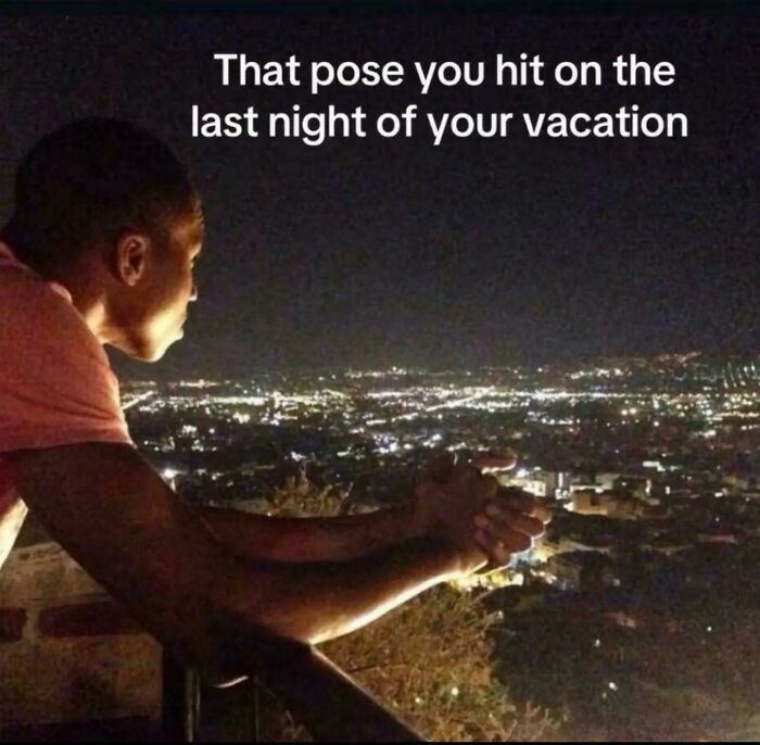 Man leaning on railing at night overlooking city lights, a relatable post from posts and memes about our lives.
