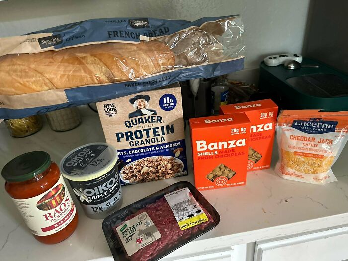 Groceries including bread, granola, pasta, cheese, yogurt, sauce, and beef showing grocery cost variations where people live.