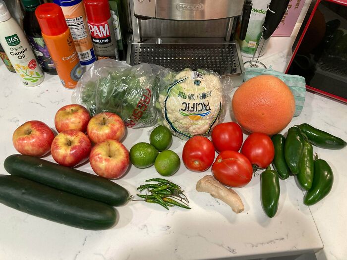 Various fresh groceries including apples, limes, zucchini, peppers, and cauliflower displayed showing grocery costs where they live.