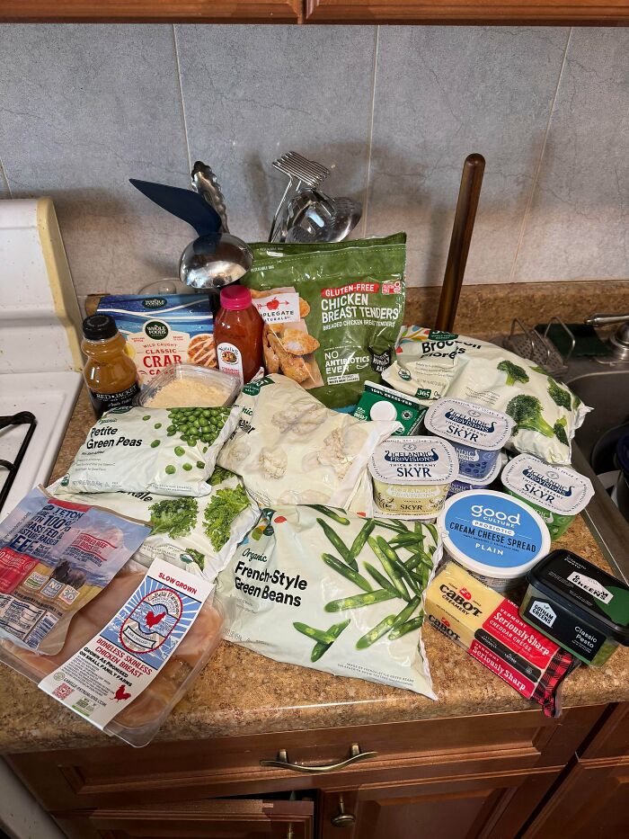 Various frozen groceries including vegetables, chicken, dairy, and snacks displayed to show grocery cost differences.