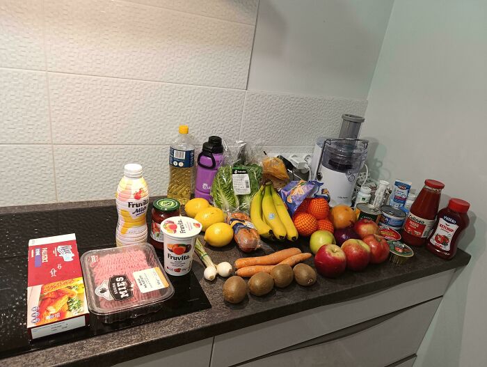 Groceries displayed on a kitchen counter showing the cost of food items where they live, highlighting grocery prices.