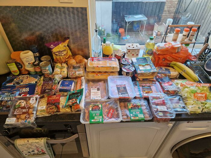 Groceries laid out on kitchen counters showing the cost of groceries where they live in a detailed comparison.