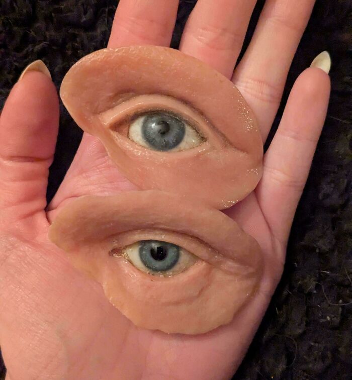 A hand holding two realistic prosthetic eyes, a truly interesting photo.