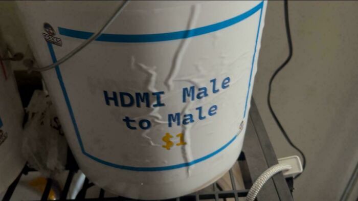 A white bucket labeled HDMI Male to Male for $1, a frugal tip for this economy.