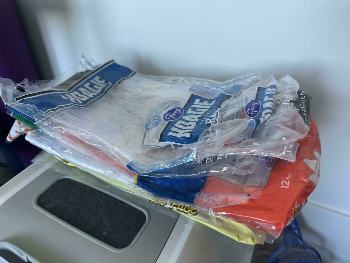 A pile of empty plastic bread bags, some with blue Hoagie branding, on a counter. Frugal tips for this economy.