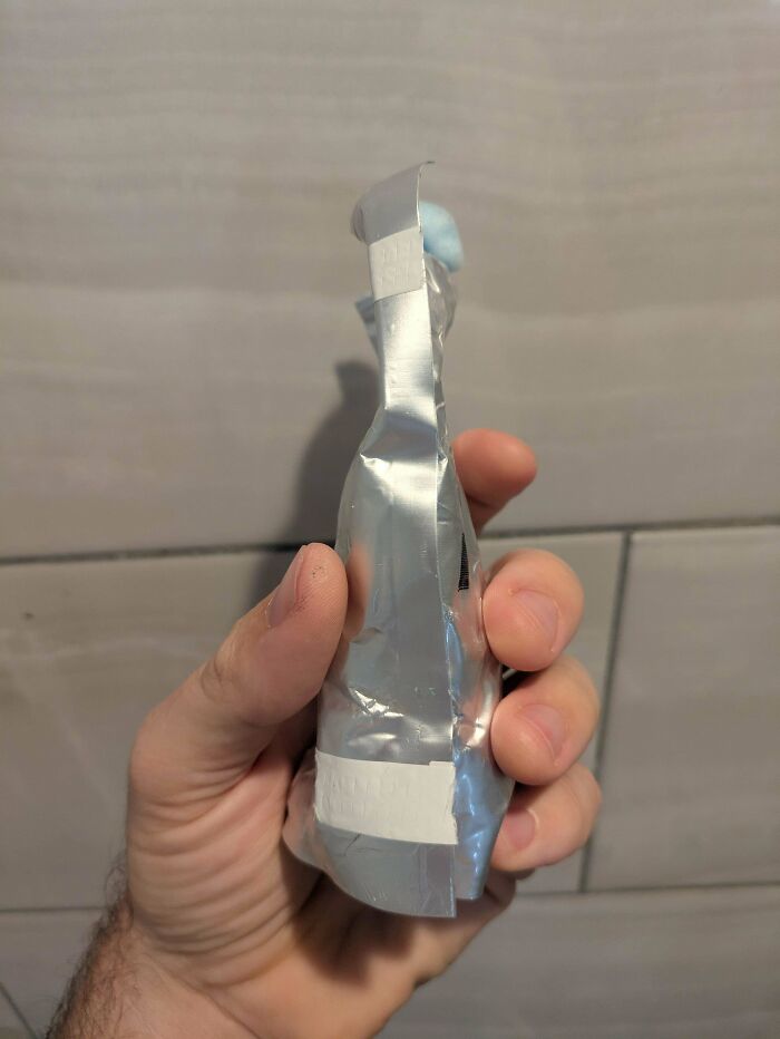 Hand holding a partially open foil package, revealing a blue item inside. Demonstrates a frugal tip for reuse.