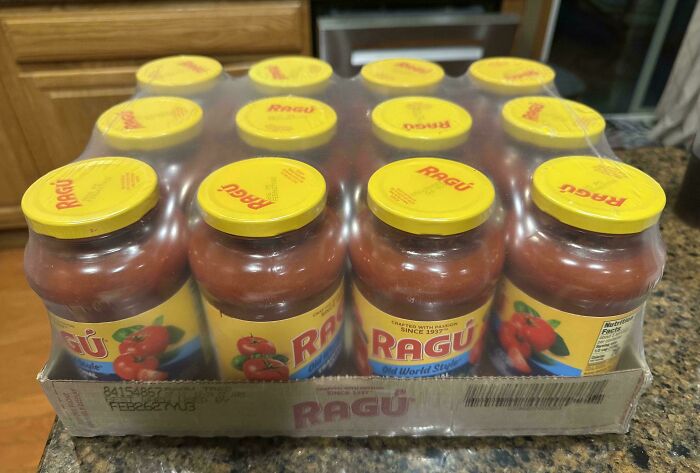 A bulk pack of twelve Ragu pasta sauce jars, wrapped in plastic, on a countertop. Frugal tips for a new world.