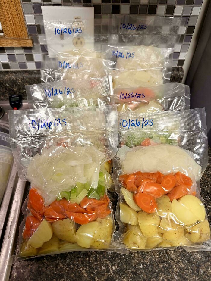 Vacuum-sealed bags of chopped vegetables, including carrots, potatoes, onions, and celery, dated 10/26/25, exemplifying frugal tips for food prep.