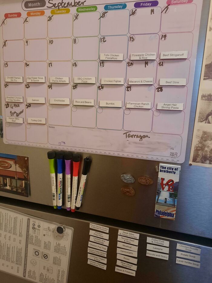 A fridge with a magnetic September calendar meal plan and markers, demonstrating frugal tips for home cooking.