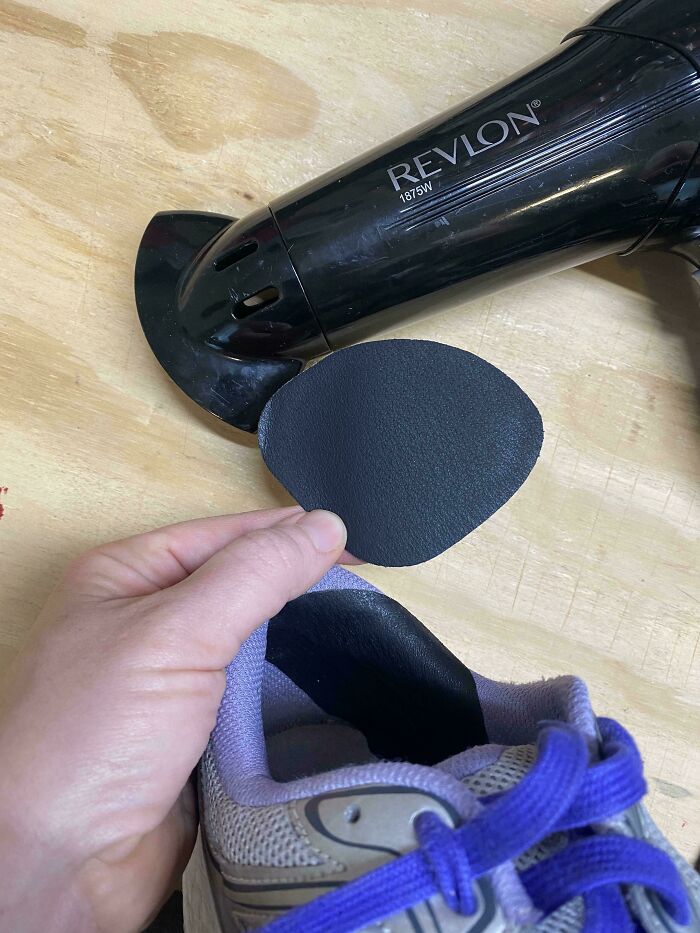 A hand inserts a shoe patch into a gray sneaker next to a Revlon hairdryer. Frugal tips for a whole new world.