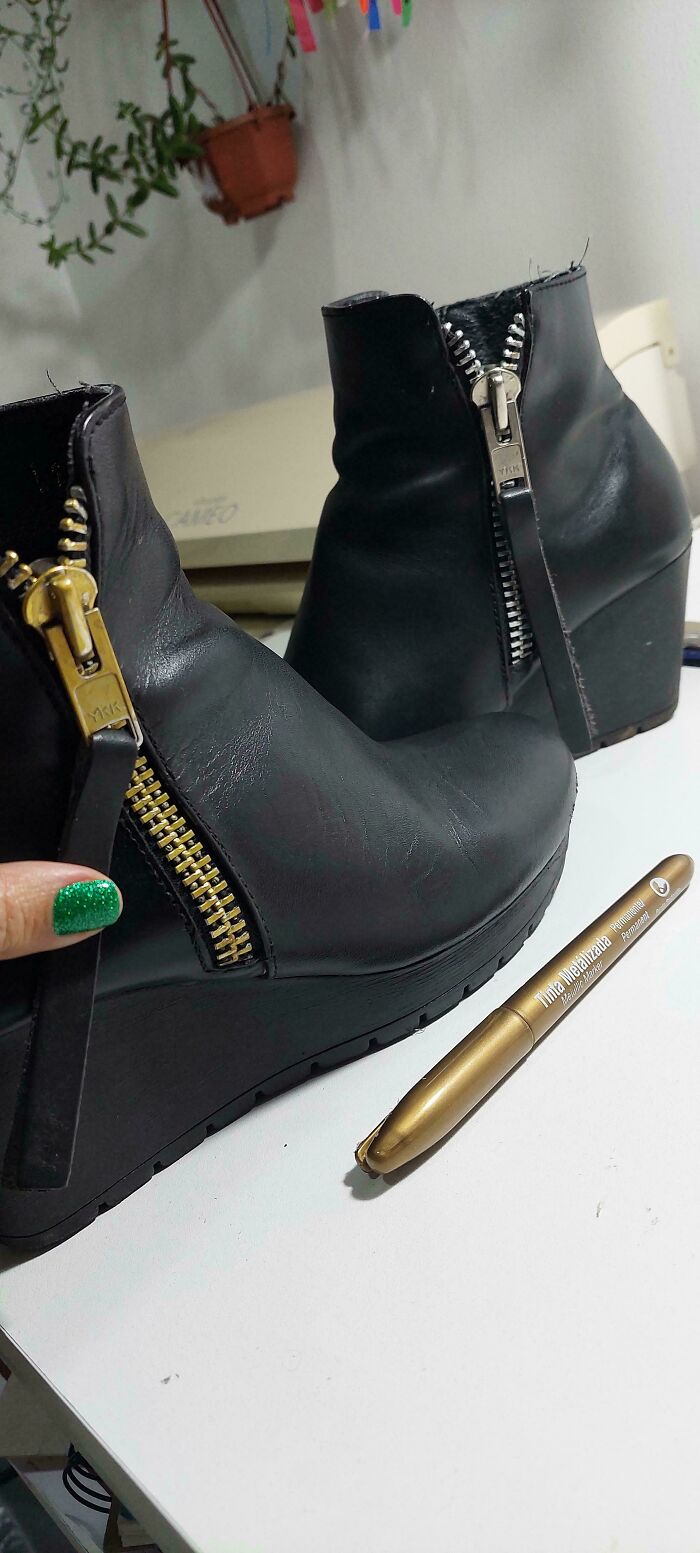 Close-up of black boots with gold zippers and a metallic marker. A hand with green nails holds a zipper. Frugal tips for this economy.