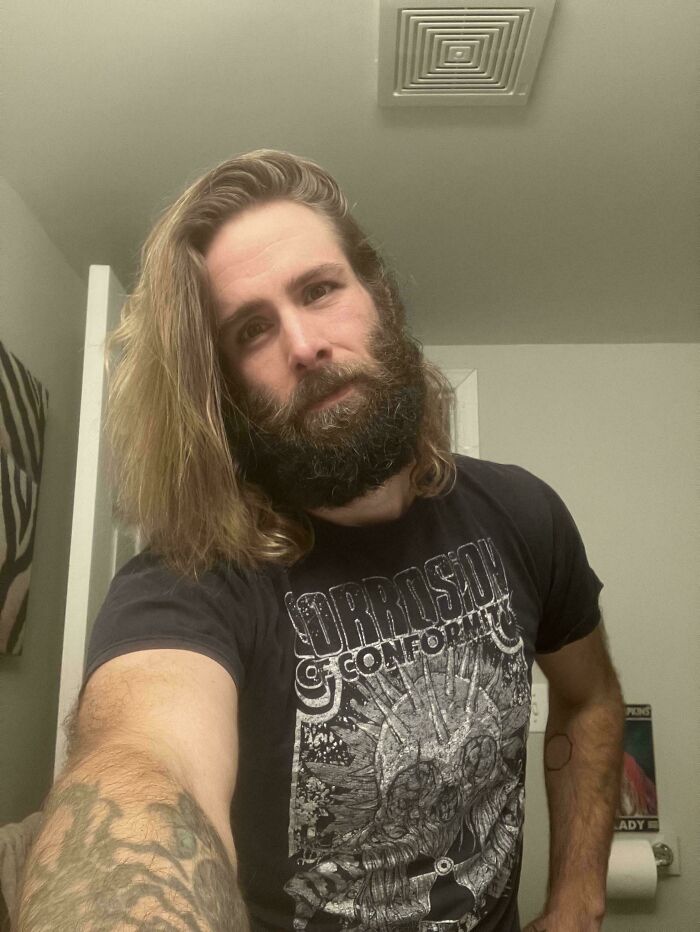 A man with ridiculously amazing long, light brown hair and a full beard poses for a selfie.