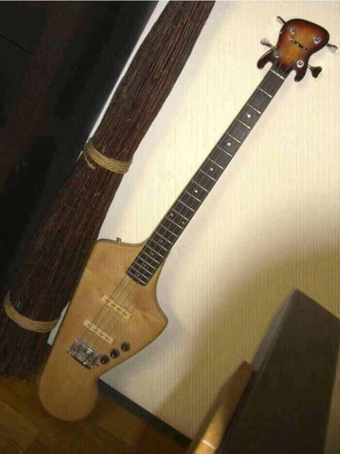 Electric guitar with extremely unusual and flawed craftsmanship design leaning against wall