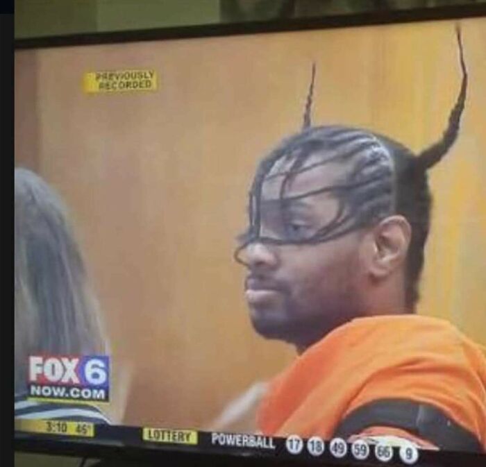 Man with intricate braided hairstyle resembling horns in courtroom news image
