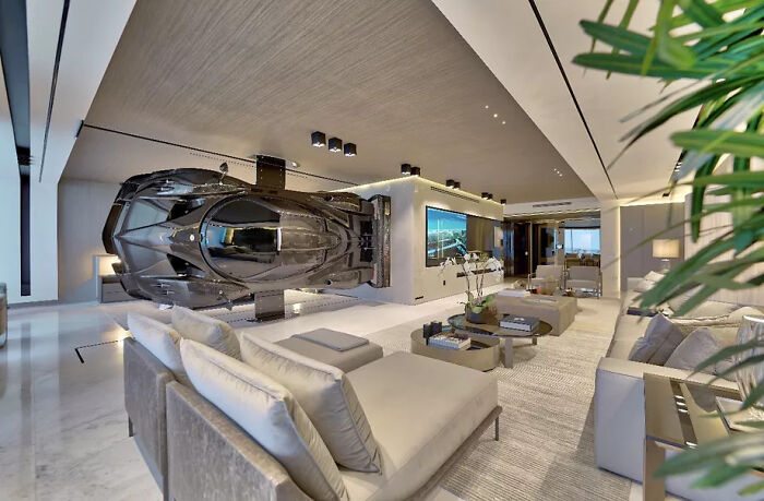 Luxury modern living room featuring a sports car displayed on the wall as flawed design