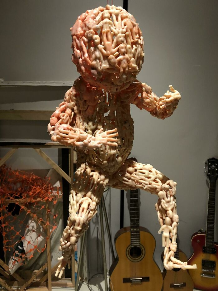 Intricate flawless craftsmanship sculpture made of small linked figures in dynamic pose