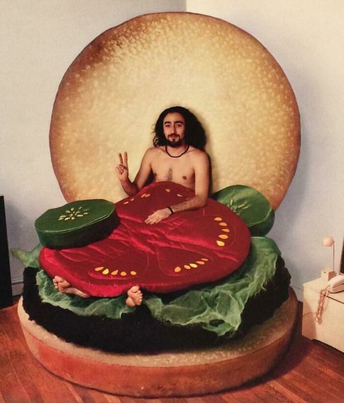 Creative flawless craftsmanship man posing inside giant hamburger bed