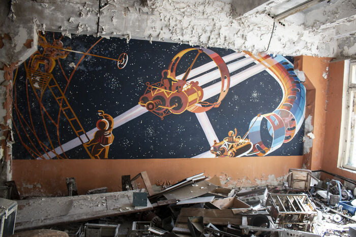 Retrofuturism colorful space exploration mural in abandoned building with debris