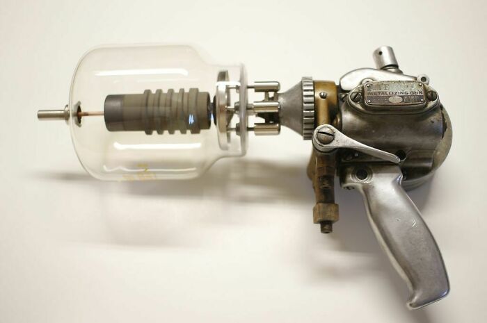 Retrofuturism vintage metal ray gun with glass chamber and mechanical details