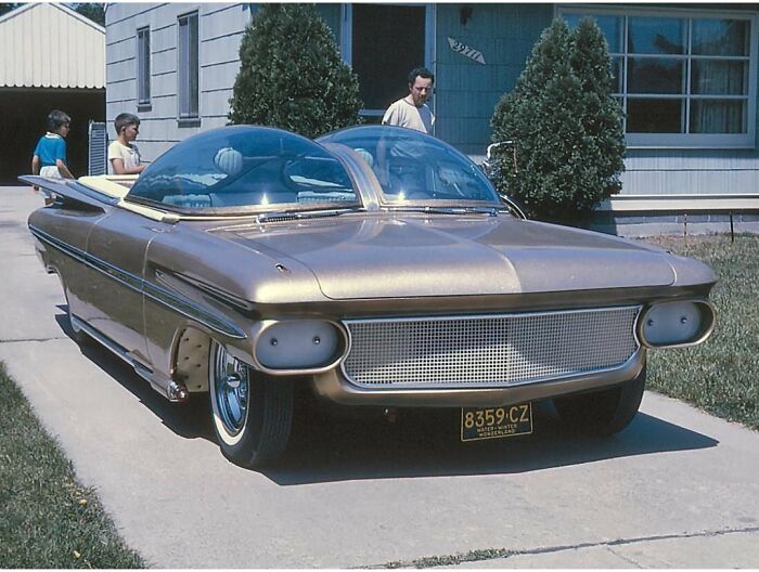 Retrofuturism vintage car with bubble domes and retro design parked outside house
