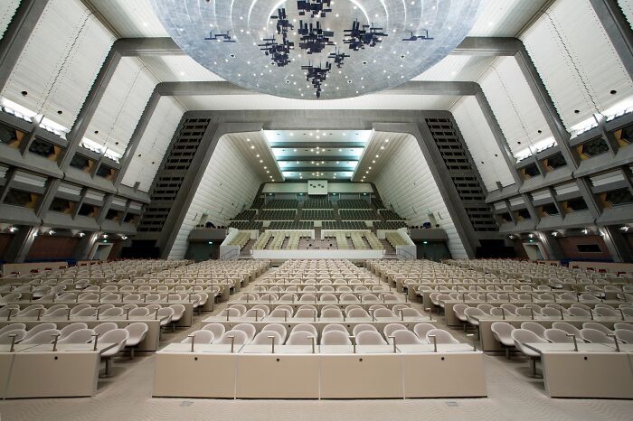 Retrofuturism interior of vast auditorium with unique geometric ceiling lights