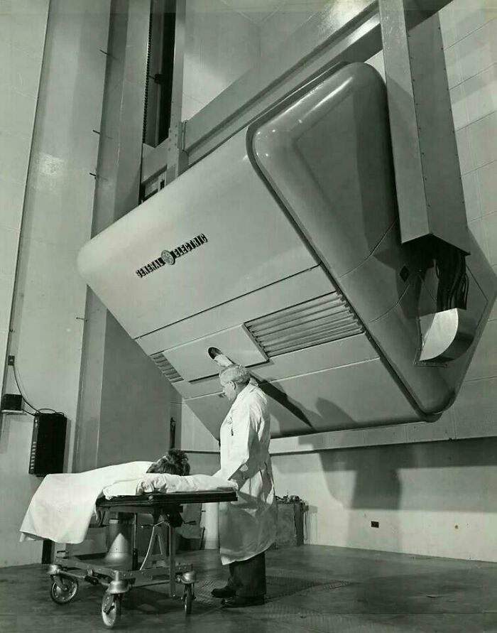 Retrofuturism vintage medical radiation therapy machine with patient and doctor in black and white