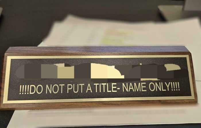 Wooden nameplate with a sign that reads do not put a title name only highlighting hilarious misprints and instruction fails.