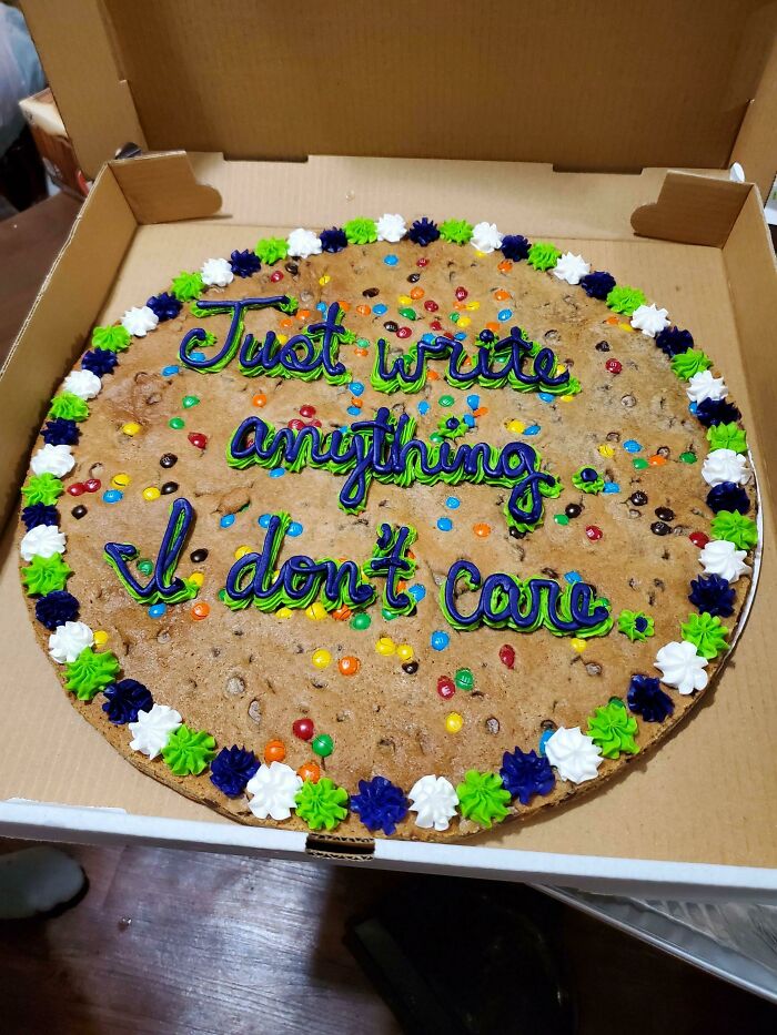Large cookie cake with colorful icing and candy, featuring a hilarious misprint of unclear instructions in the decoration.