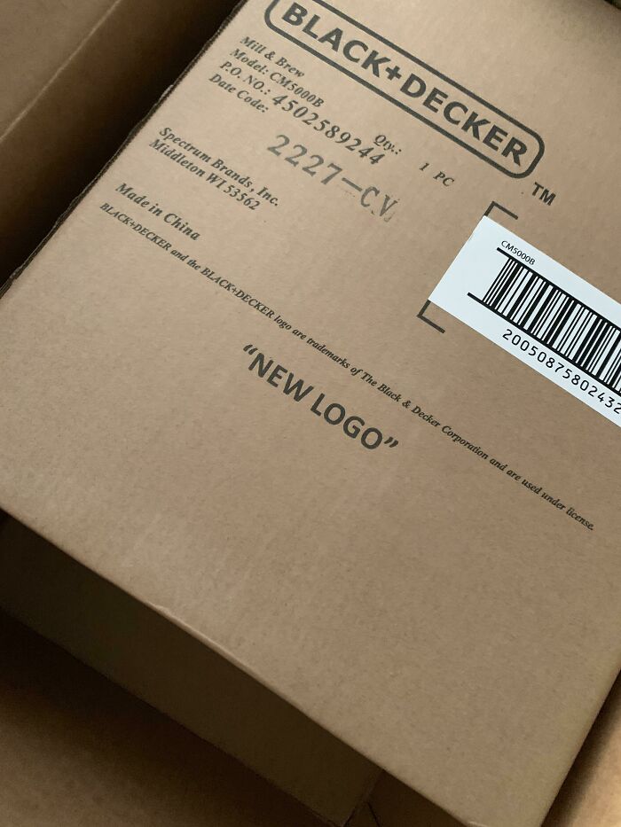 Cardboard box with Black+Decker branding and the phrase NEW LOGO printed literally, a hilarious misprint example.