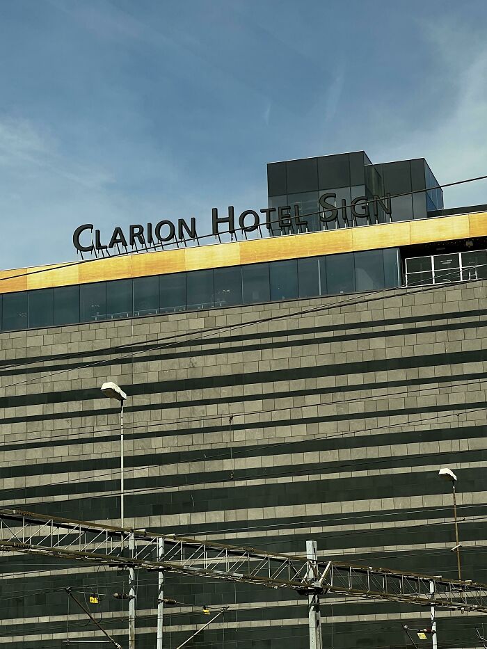 Hotel sign with missing letters causing a hilarious misprint fail on top of modern building under clear sky.