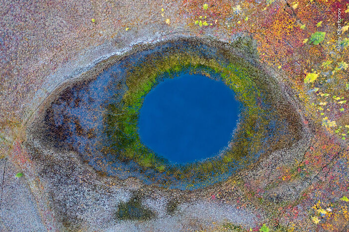 Aerial view of a natural pool resembling an eye, showcasing stunning colors in a Wildlife Photographer of the Year winning image.