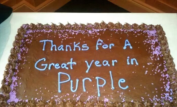 Chocolate cake with blue icing text reading thanks for a great year in purple, a hilarious misprint example