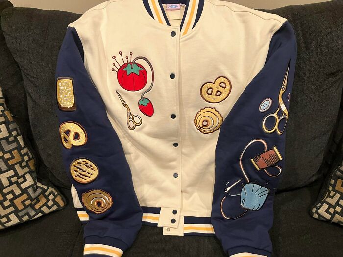 A unique jacket with embroidery of sewing items and pretzels, a jackpot find from a thrift store.