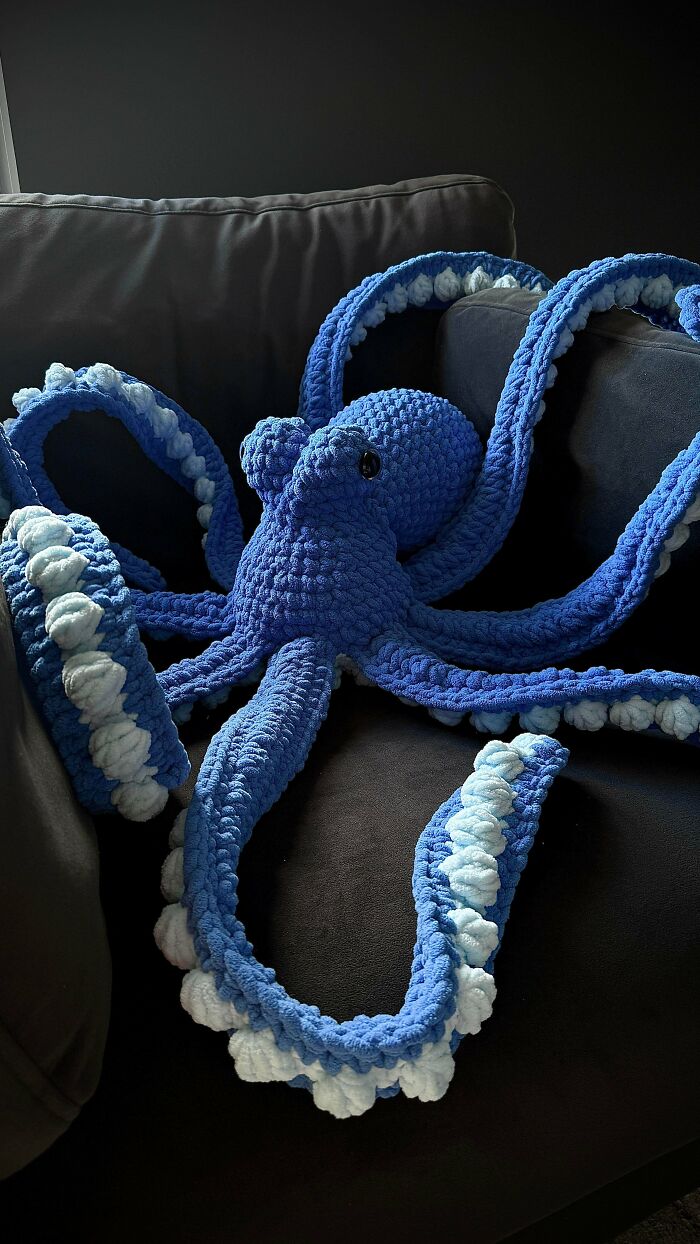 A blue crocheted octopus with lighter blue and white suckers on its tentacles, an awesome handcrafted creation.