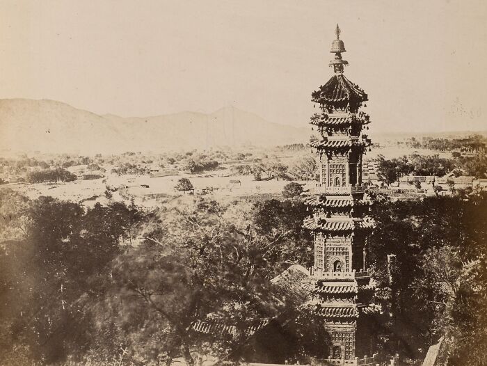Ancient pagoda surrounded by trees and distant mountains, one of the interesting buildings lost as the world changed.