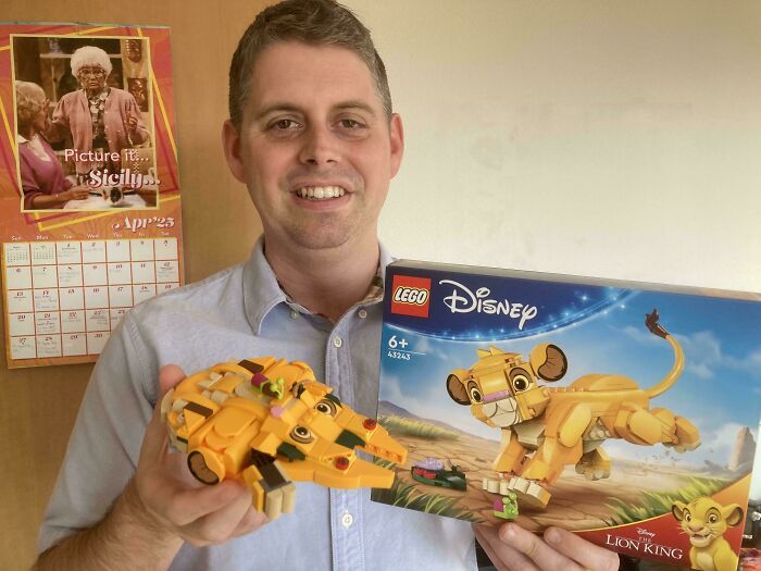 Man smiling and holding a LEGO Disney Lion King set and built model, showcasing a funny photo that says it all instantly.