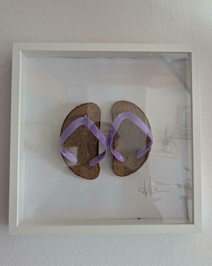 Slices of bread with purple flip-flop straps framed as a DIY project gone deeply cursed on a wall.